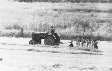 Bauer beim Heuwenden mit dem Trecker
